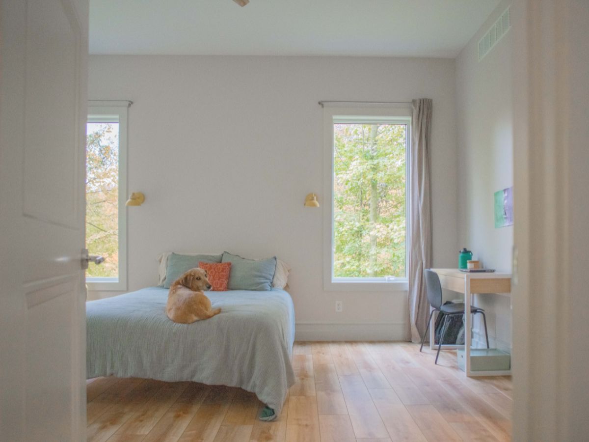 Bright bedroom with large windows and wooden floors in a modern cottage, DESIGN WITH FRANK.