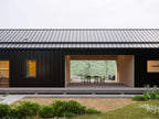 Modern dogtrot house plan interior — U-shaped kitchen with island and sliding glass doors