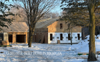 3 bedroom modern ranch house built in Michigan — winter construction photo of the 2,079 sqft modern farmhouse plan with screen porch and attached garage