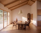 Dining area with wood table in open-concept single-story house plan