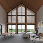 Lake barndominium interior — double-height open-concept living and dining area with large windows