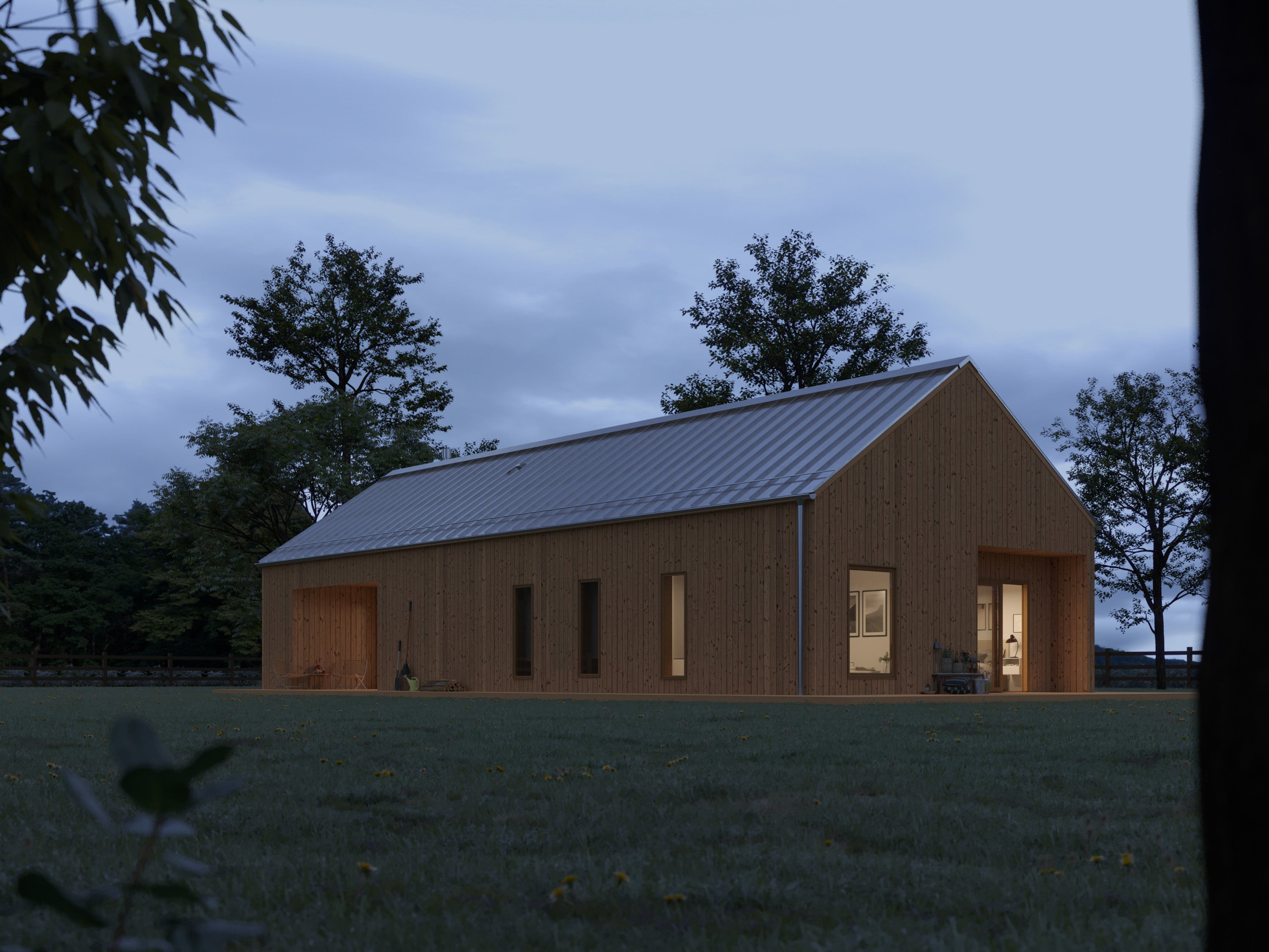 Natural wood barn house with vertical timber cladding and silver pitched metal roof at dusk, side elevation with warm interior lighting visible through bedroom and living room windows at twilight