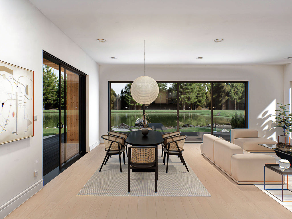 Barndominium house plan open concept dining and living area with black-frame sliding doors and waterfront backyard view