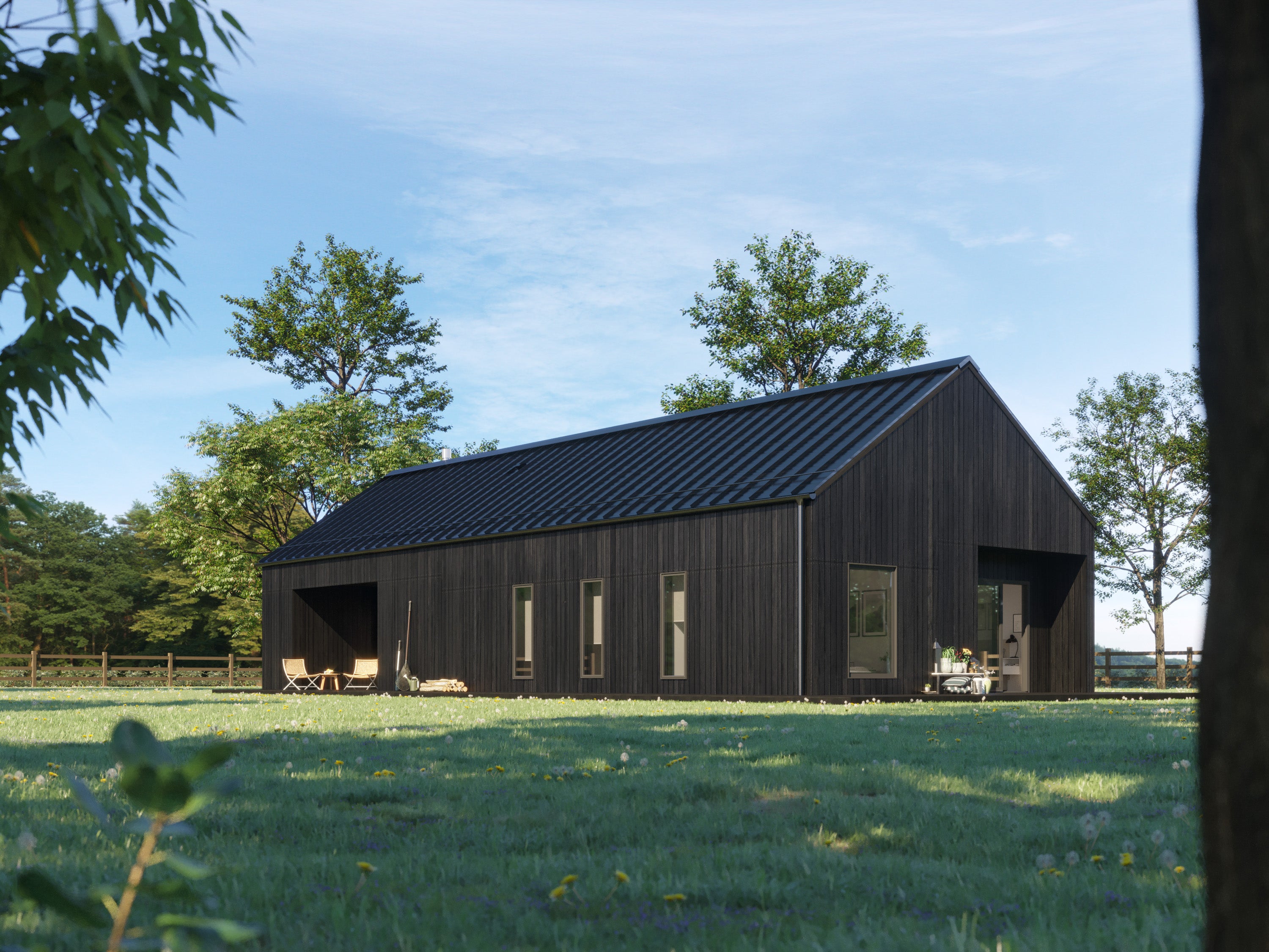 Contemporary black barn home with charred wood vertical siding and black pitched metal roof, daytime side elevation showing covered porch area, narrow windows, and recessed gable-end entrance in green meadow setting