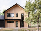 Nordic barndominium floor plan front entry elevation with natural wood vertical siding, black trim, 2-story gable and stepping stone pathway