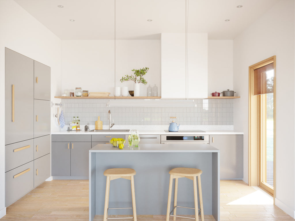 Bright modern kitchen interior with grey flat-front cabinets, brass hardware, white tile backsplash, open wood shelving, grey island with bar stools, and light oak herringbone floor