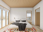 Modern cabin house plan primary bedroom — sliding glass doors to the view, wood plank ceiling and platform bed