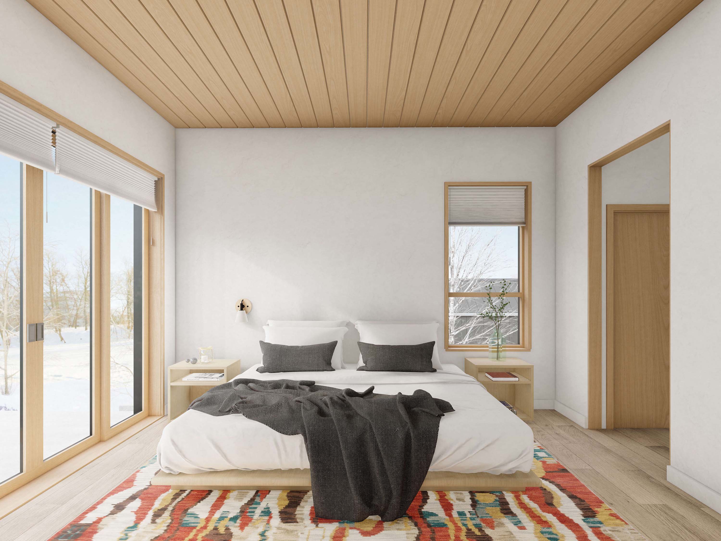 Modern cabin house plan primary bedroom with sliding glass doors to winter landscape, wood plank ceiling, platform bed and warm wood-frame windows