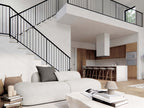 Nordic barndominium open concept living room with loft and black iron staircase, neutral sectional sofa and open kitchen with island visible
